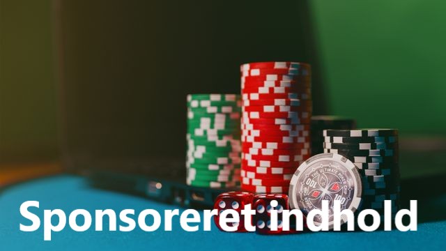Stakke med røde, grønne og sorte casino chips med røde terninger foran, placeret på et casinobord